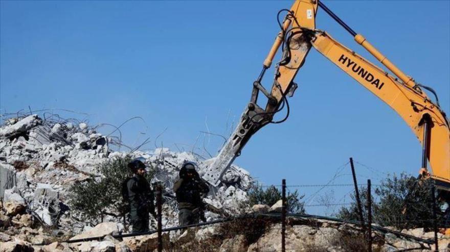 Fuerzas israelíes tratan de mantener alejados a palestinos, cuyas viviendas están siendo demolidas, Cisjordania.