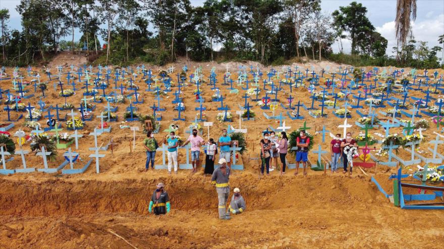 Personas con mascarillas han excavado nuevas tumbas en un cementerio en la selva amazónica de Brasil, 22 de abril de 2020.