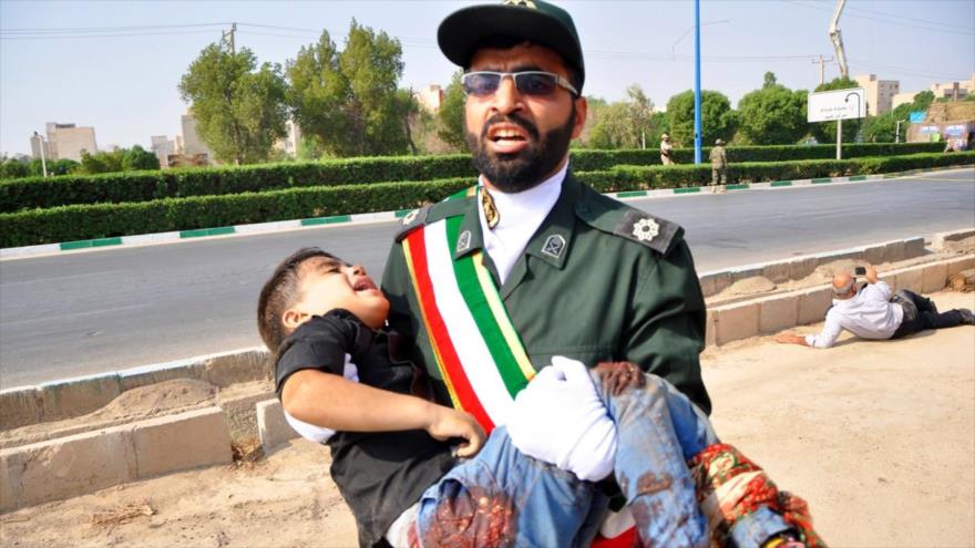 Un militar iraní lleva a un niño herido tras un ataque terrorista en un desfile militar en la ciudad de Ahvaz, 22 de septiembre de 2019. (Foto: AFP)