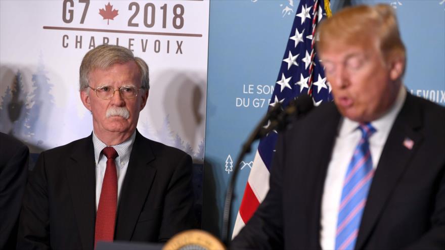 El exasesor de Seguridad Nacional de EE.UU. John Bolton (izda.) escucha al presidente Donald Trump en una reunión del G7 en Canadá.