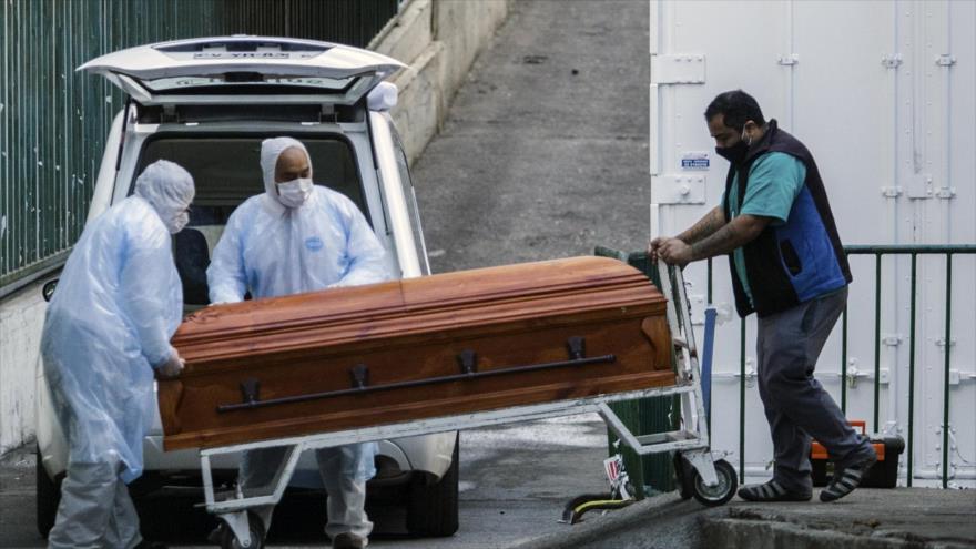 Los empleados de una funeraria llevan el ataúd de una víctima de la COVID-19 a un vehículo, afuera de un hospital en Chile, 12 de junio de 2020. (Foto: AFP)
