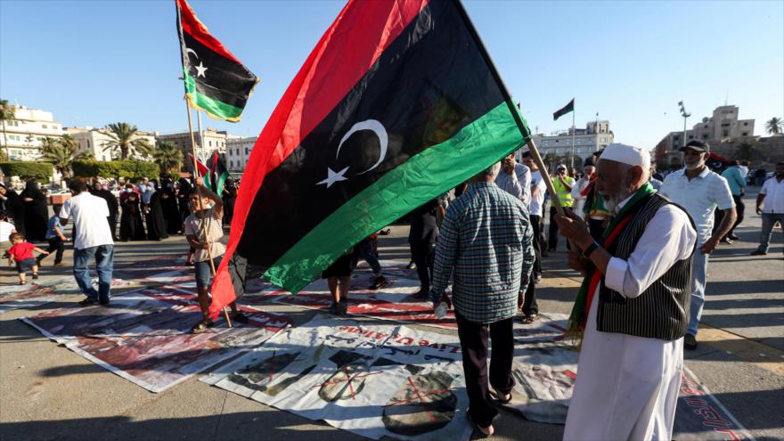 Un hombre ondea una bandera nacional de Libia en el centro de la capital libia, Trípoli, en manos del Gobierno de Acuerdo Nacional (GNA), 21 de junio de 2020. (Foto: AFP)