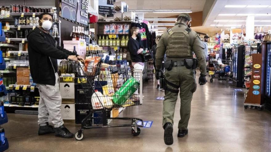 Un alguacil patrulla un supermercado en Los Ángeles, para que se mantenga el distanciamiento social. (Foto: EFE)