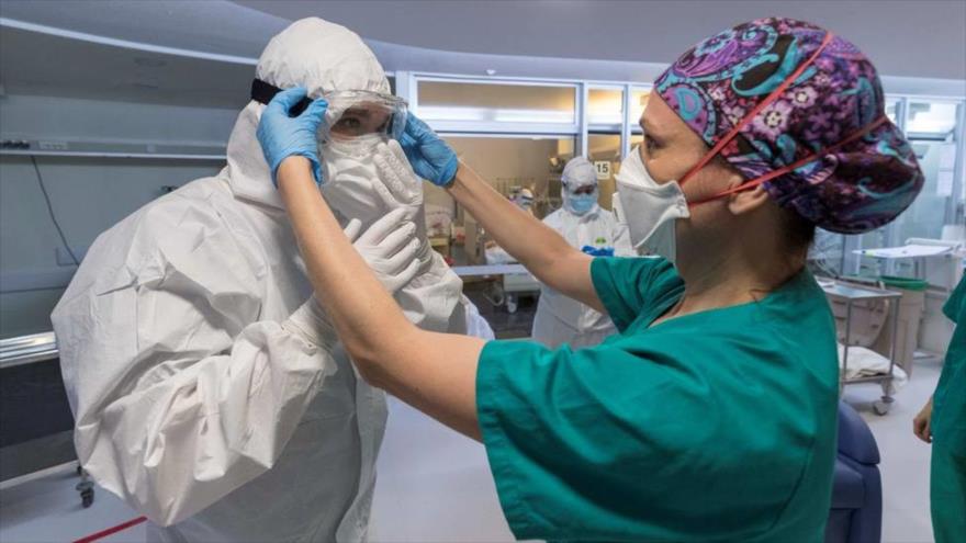 Profesional sanitario con mascarilla y gafas protectoras se preparan para atender a enfermos contagiados por la COVID-19.