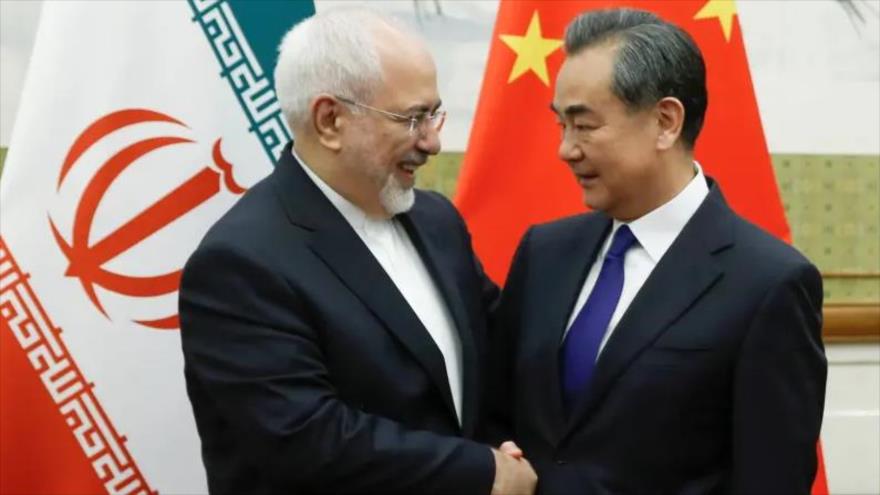 El canciller iraní, Mohamad Yavad Zarif (izda.), saluda a su homólogo chino, Wang Yi, en una reunión en Pekín, 13 de mayo de 2018. (Foto: Reuters)
