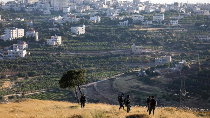 Guardias fronterizos israelíes patrullan frente a las colonias israelíes cerca de Al-Jalil, en la Cisjordania ocupada, 30 de junio de 2020. (Foto: AFP)
