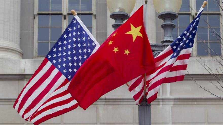 Banderas de EE.UU. y China izadas frente la embajada norteamericana en Pekín.

