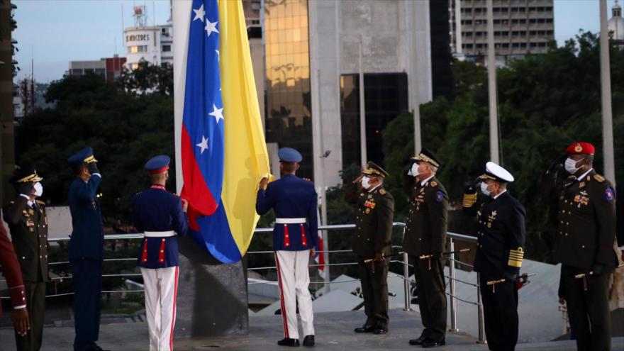 
El ministro de Defensa venezolano junto con otros militares y funcionarios del país izan la bandera de Venezuela en conmemoración del natalicio de Simón Bolívar.