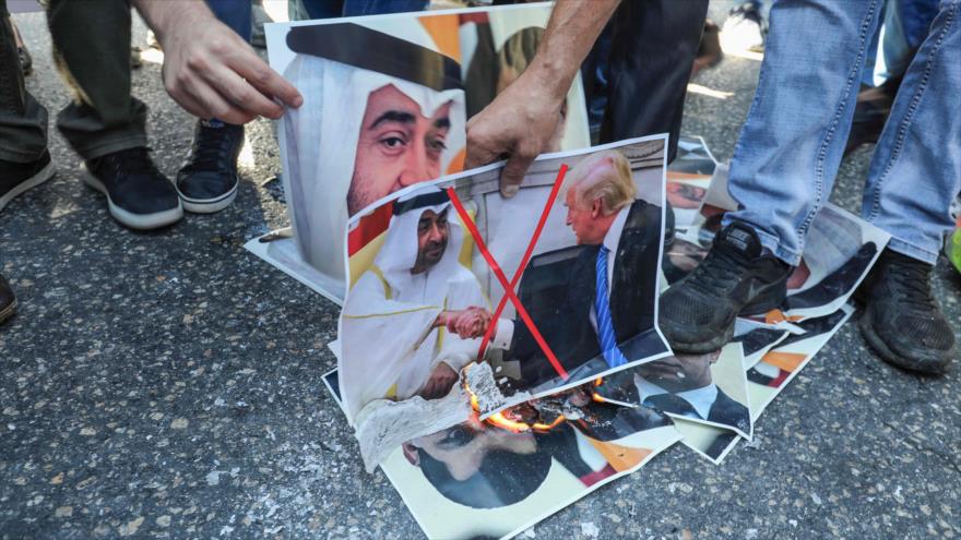 Palestinos queman fotografías del príncipe heredero de los EAU, Muhamad bin Zayed Al Nahyan, en una protesta en Ramalá, 15 de agosto de 2020. (Foto: AFP)