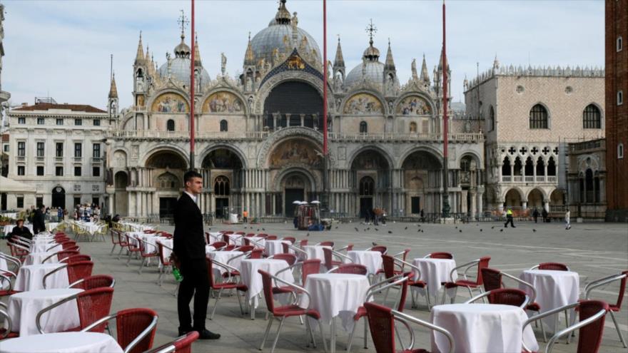 Un camarero está de pie junto a las mesas vacías de un restaurante en la Plaza de San Marcos, en Venecia, Italia, 9 de marzo de 2020. (Foto: Reuters)