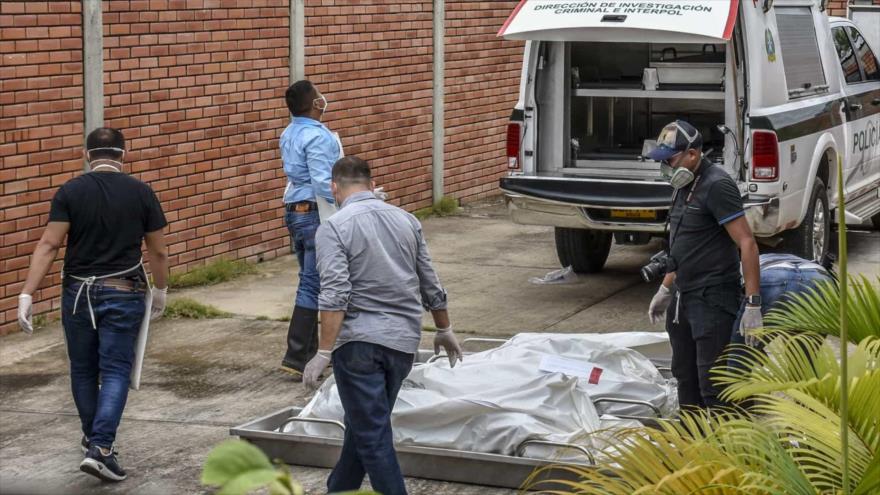 Policías colombianos junto a cadáveres de víctimas de una masacre en el municipio de Arauca, Colombia. (Foto: AFP)