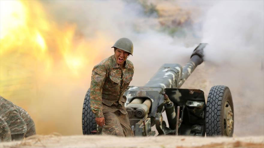 Un militar del ejército de defensa de Nagorno Karabaj dispara una pieza de artillería hacia posiciones azerbaiyanas, 28 de septiembre de 2020. (Foto: AFP)