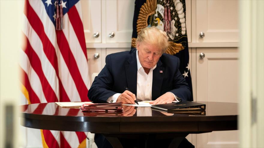 El presidente de EE.UU., Donald Trump, firma un documento en el hospital militar de Walter Reed, el 3 de noviembre de 2020. (Foto: AFP)