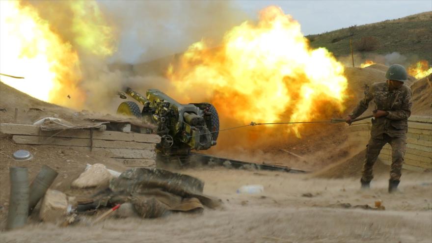 Un militar del Ejército de Karabaj dispara una pieza de artillería hacia posiciones azerbaiyanas, 4 de octubre de 2020. (Foto: AFP)