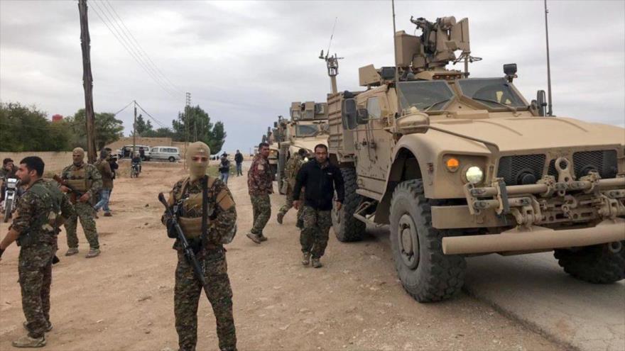 Miembros de las llamadas Fuerzas Democráticas Sirias (FDS) delante de vehículos blindados de EE.UU. en una región en el norte de Siria.