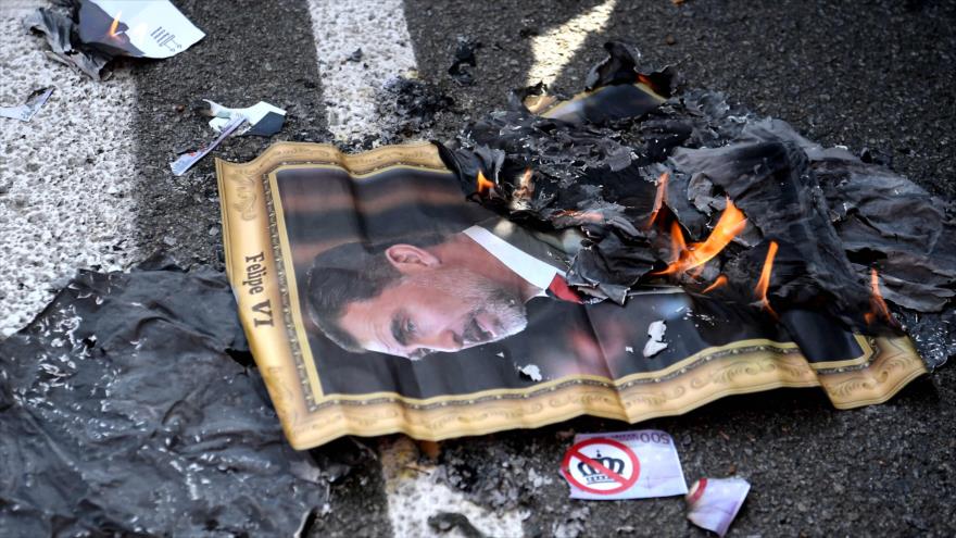 Manifestantes antimonárquicos queman una foto del rey español, Felipe VI, durante una protesta en Barcelona, 9 de octubre de 2020. (Foto: AFP)