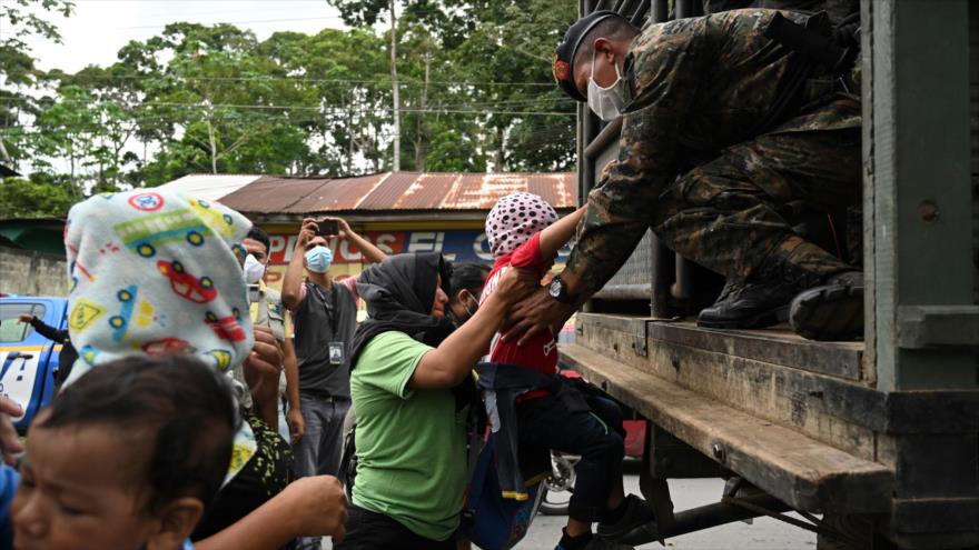 Los migrantes hondureños que se dirigían a EE.UU., se sientan en un camión del Ejército guatemalteco, en Entre Ríos, Guatemala, 2 de octubre de 2020. (Foto: AFP)