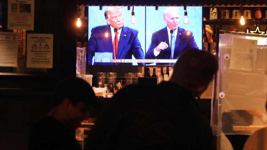 La gente observa el debate electoral entre el presidente de EE.UU., Donald Trump y su rival Joe Biden en Nueva York, 22 de octubre de 2020. (Foto: AFP)