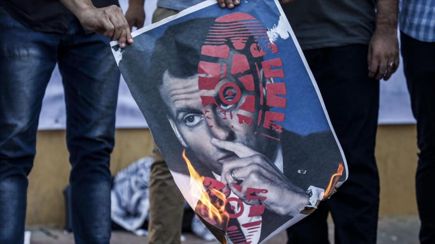 Palestinos prenden fuego a una imagen del presidente francés, Emmanuel Macron, en la Franja de Gaza, 27 de octubre de 2020. (Foto: AFP)