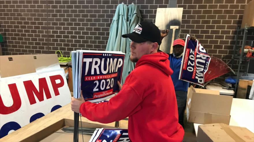 Jack Worthington (izq.), un partidario de Donald Trump, prepara las pancartas electorales en Newtown, Pensilvania, 28 de octubre de 2020. (Foto: AFP)