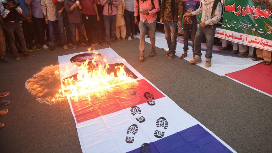 Ciudadanos paquistaníes queman una bandera francesa y un cartel del presidente francés, Emmanuel Macron, Karachi, 1 de noviembre de 2020. (Foto: AFP)