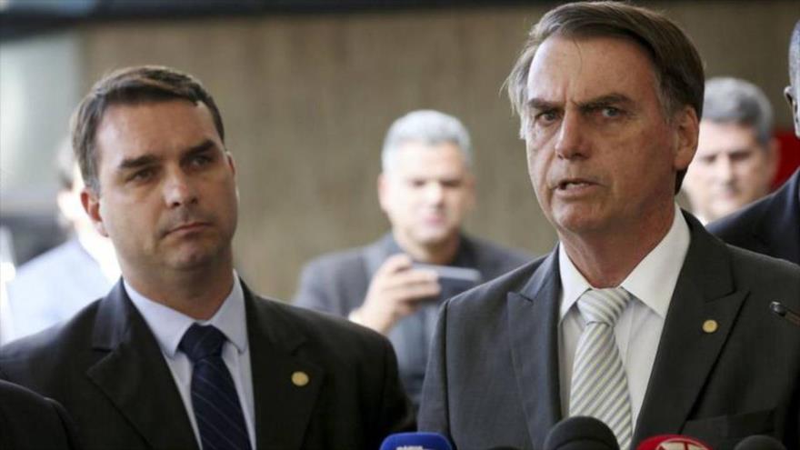 El presidente de Brasil, Jair Bolsonaro (izda.) y su hijo Flavio llegan a una conferencia de prensa en Brasilia.