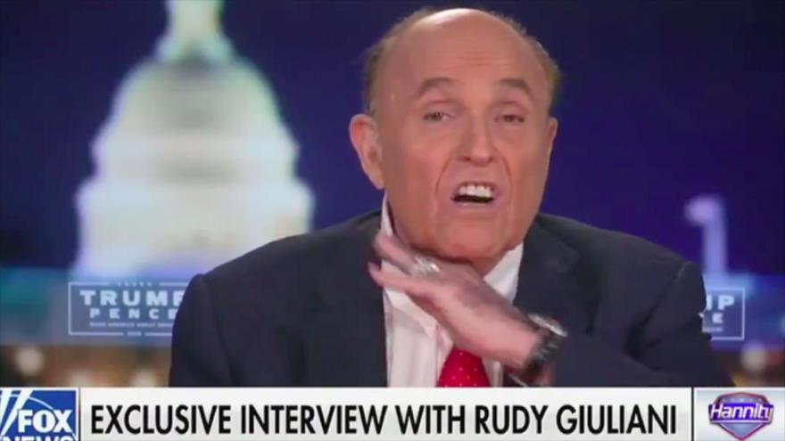 Rudy Giuliani, abogado personal de Trump, hace un gesto con la mano de cortarse la garganta en una entrevista con Fox News, 19 de noviembre de 2020.