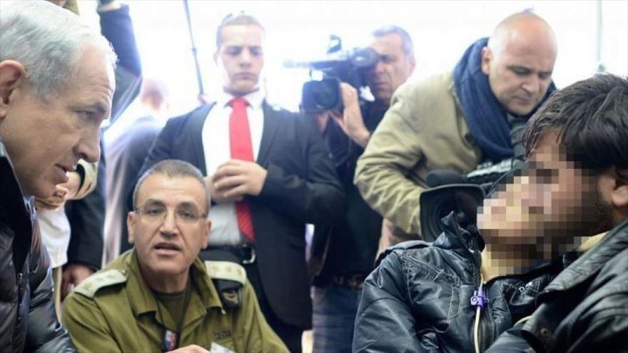 El premier israelí, Benjamín Netanyahu, visita a un grupo de opositores heridos en un hospital de campaña en el norte de Israel, 18 de febrero de 2014. 