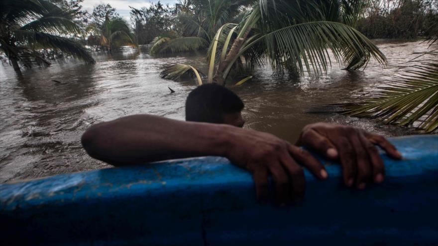 Un hombre se aferra a una canoa en un área inundada después del paso del huracán Iota en Puerto Cabezas, Nicaragua, 18 de noviembre de 2020.