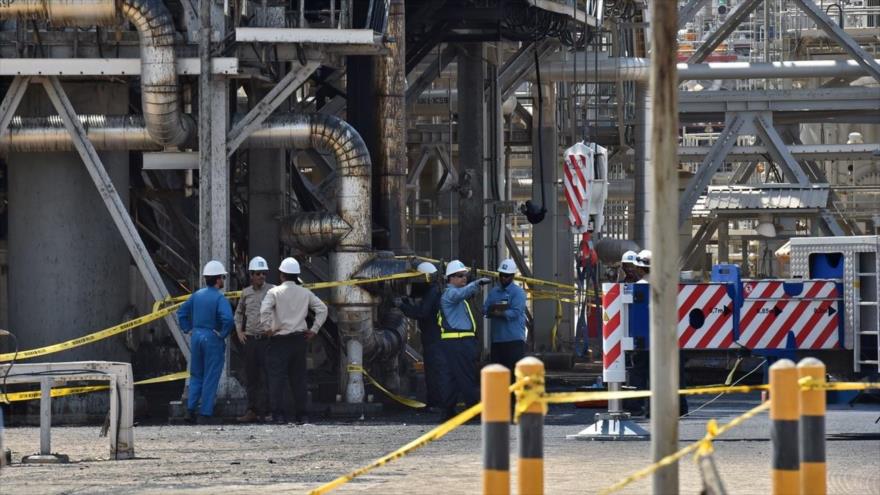 Empleados de la petrolera saudí Aramco cerca de una instalación muy dañada tras un ataque yemení, 20 de septiembre de 2019. (Foto: AFP)