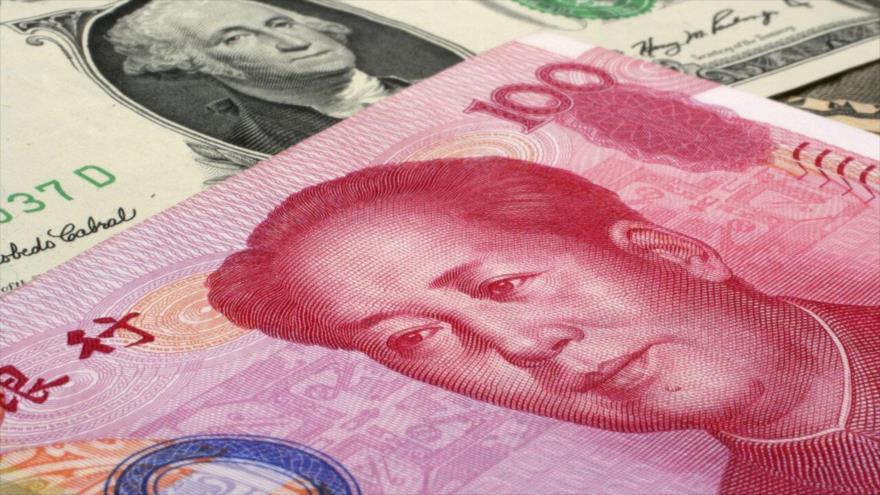Billete de 100 yuanes, de China, sobre uno de 100 dólares estadounidense.