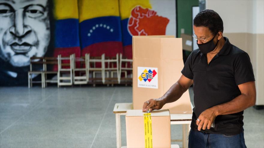 Un hombre deposita su voto en un colegio electoral de una escuela de Caracas, capital de Venezuela, 6 de diciembre de 2020. (Foto: AFP)