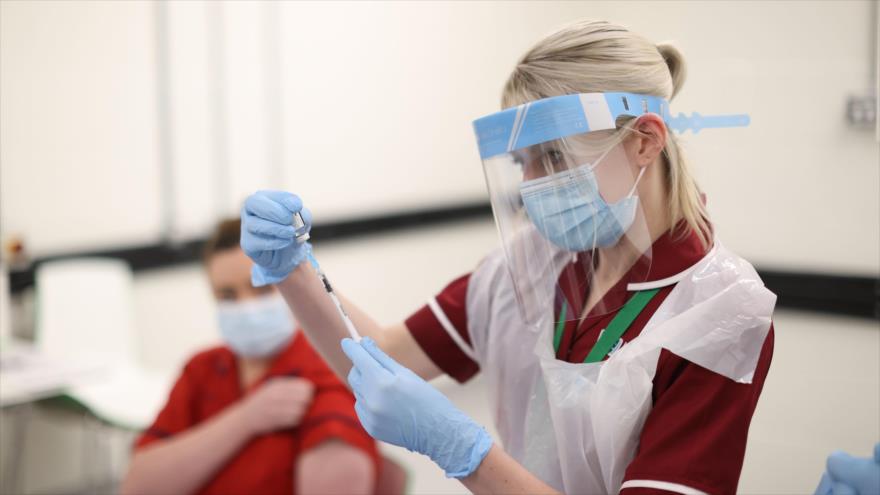 Una enfermera llena una aguja con la vacuna contra el nuevo coronavirus en un hospital en Belfast (Irlanda del Norte), 8 de diciembre de 2020. (Foto: AFP)