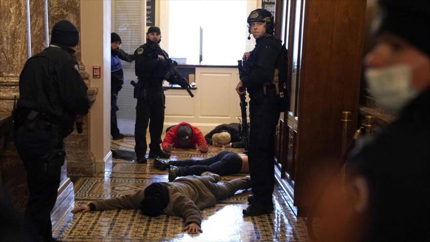 Oficiales de policía detienen a simpatizantes de Donald Trump tras un asalto al Capitolio, 6 de enero de 2021. (Foto: AFP)