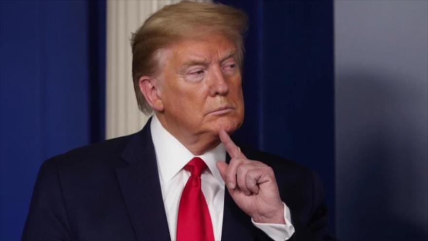 El presidente saliente de EE.UU., Donald Trump, sujeta su barbilla de la cara en una pose pensativa para unos reporteros gráficos en la Casa Blanca. (Foto: Reuters) 