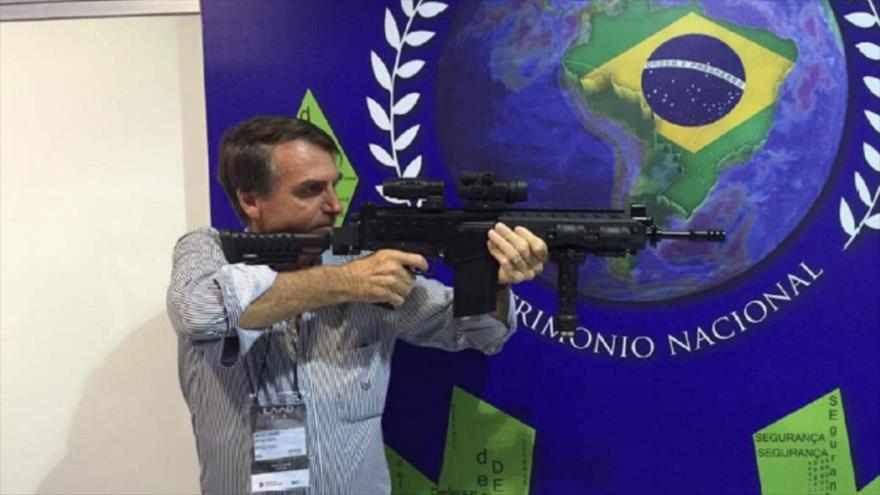 Presidente de Brasil, Jair Bolsonaro, en posición de tiro en la prueba de un rifle.