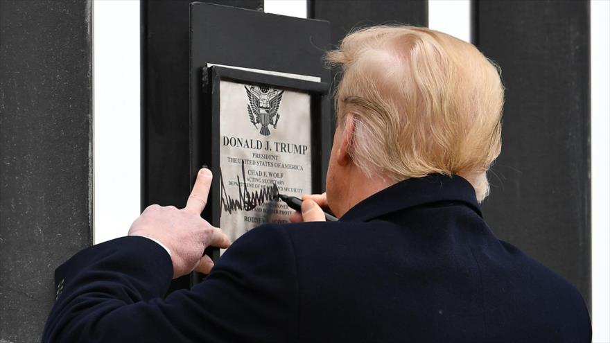 El presidente de EE.UU., Donald Trump, firma una placa en el muro fronterizo en Texas, 12 de enero de 2021. (Foto: AFP)