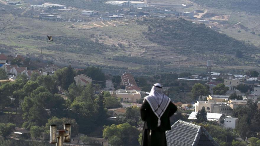 Un palestino mira hacia la colonia israelí construida junto al pueblo palestino de Naqoura en la ocupada Cisjordania, 23 de noviembre de 2020. (Foto: AFP)