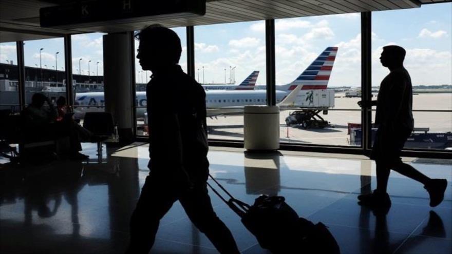 Varios pasajeros se dirigen a la puerta de embarque de su vuelo en el Aeropuerto Internacional OHare de Chicago, situado en el estado de Illinois, EE.UU.