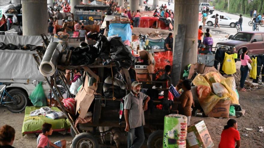 La gente permanece debajo de un puente tras el paso del huracán Iota en San Pedro Sula, 21 de noviembre de 2020. (Foto: AFP)