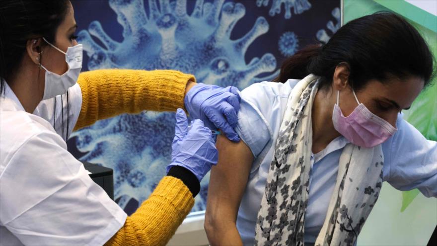 Una mujer israelí recibe la vacuna anti-COVID-19 en Al-Quds (Jerusalén), 21 de enero de 2021. (Foto: AFP)