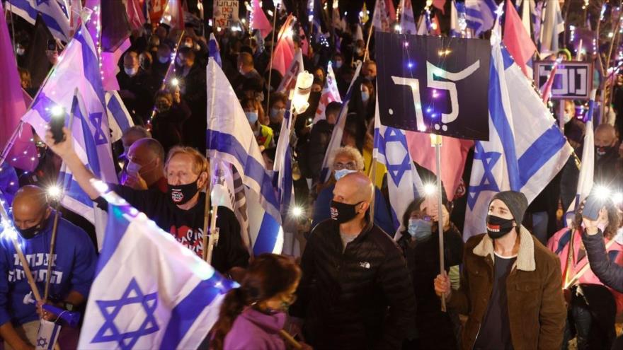 Israelíes protestan contra el primer ministro del régimen de Tel Aviv, Benjamín Netanyahu, en Cesarea, 12 de diciembre de 2020. (Foto: AFP)