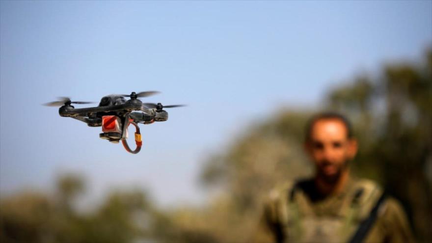 Un soldado israelí mira un cuadricóptero israelí.