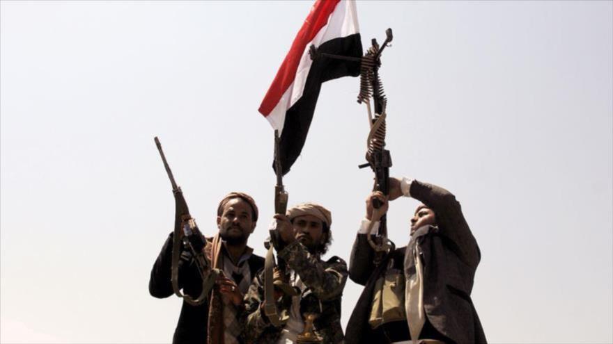 Combatientes del movimiento popular yemení Ansarolá enarbolan la bandera nacional.
