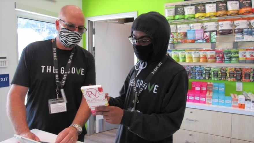 Un empleado de un centro de venta de marihuana despacha a un cliente en su local, en localidad de La Mesa, California (EE.UU.)