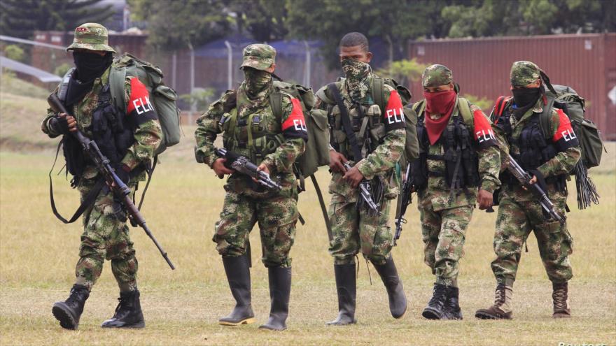 Miembros de la guerrilla colombiana ELN caminan hacia una base militar para entregar sus armas.