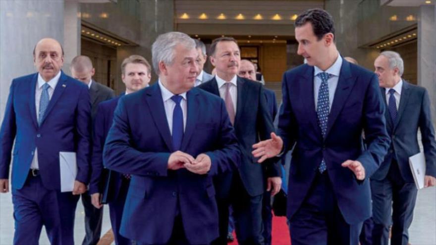 El presidente sirio Bashar al-Asad (decha.) y el especial del presidente ruso a Siria, Alexander Lavrentiev, 12 de julio de 2019 (Foto: AFP).