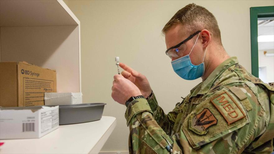 Un soldado de EE.UU. llena jeringuillas con la vacuna anti-COVID-19 en un centro de vacunación en Massachusetts, 16 de febrero de 2021. (Foto: AFP)