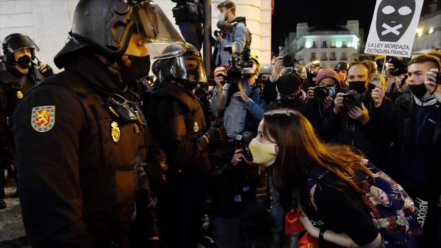 Un grupo de manifestantes congregados en la Puerta del Sol de Madrid porta pancartas en apoyo al rapero catalán encarcelado Pablo Hasél, 17 de febrero de 2021. (Foto: AFP)