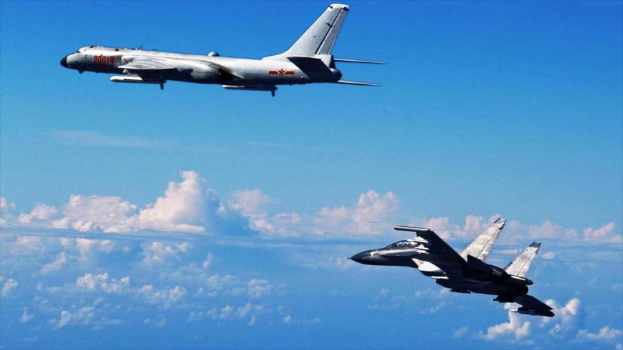 Un caza Su-30 chino (dcha.) en pleno vuelo, junto a un bombardero H-6K durante unos simulacros cerca del mar de la China Oriental. (Foto: Xinhua)